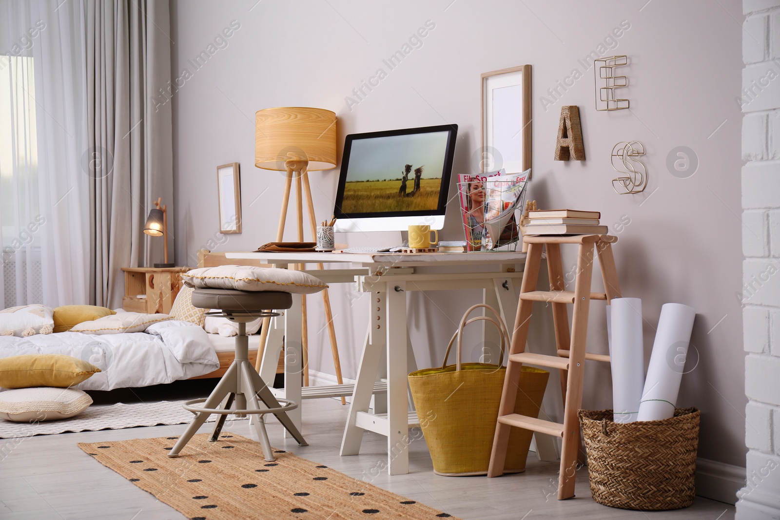 Photo of Comfortable workplace with modern computer near light wall in bedroom. Interior design