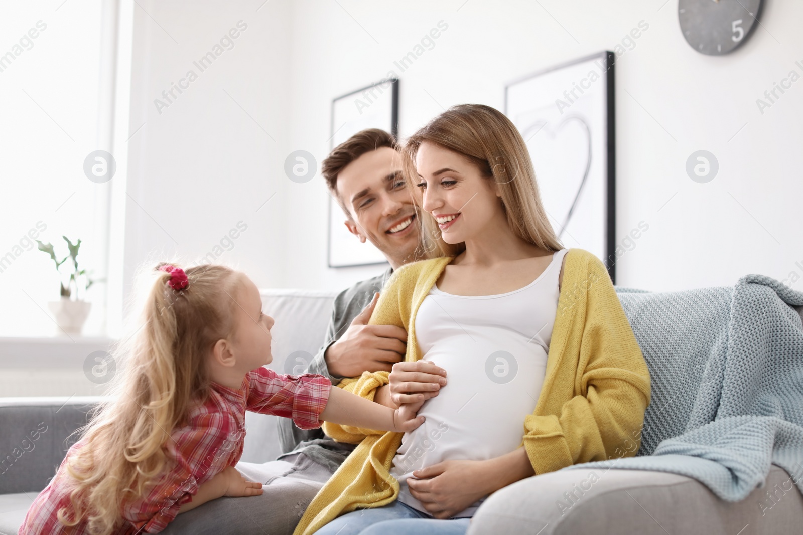 Photo of Young pregnant woman with her family at home