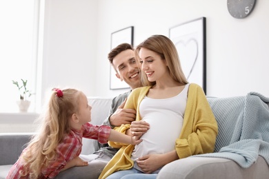 Photo of Young pregnant woman with her family at home