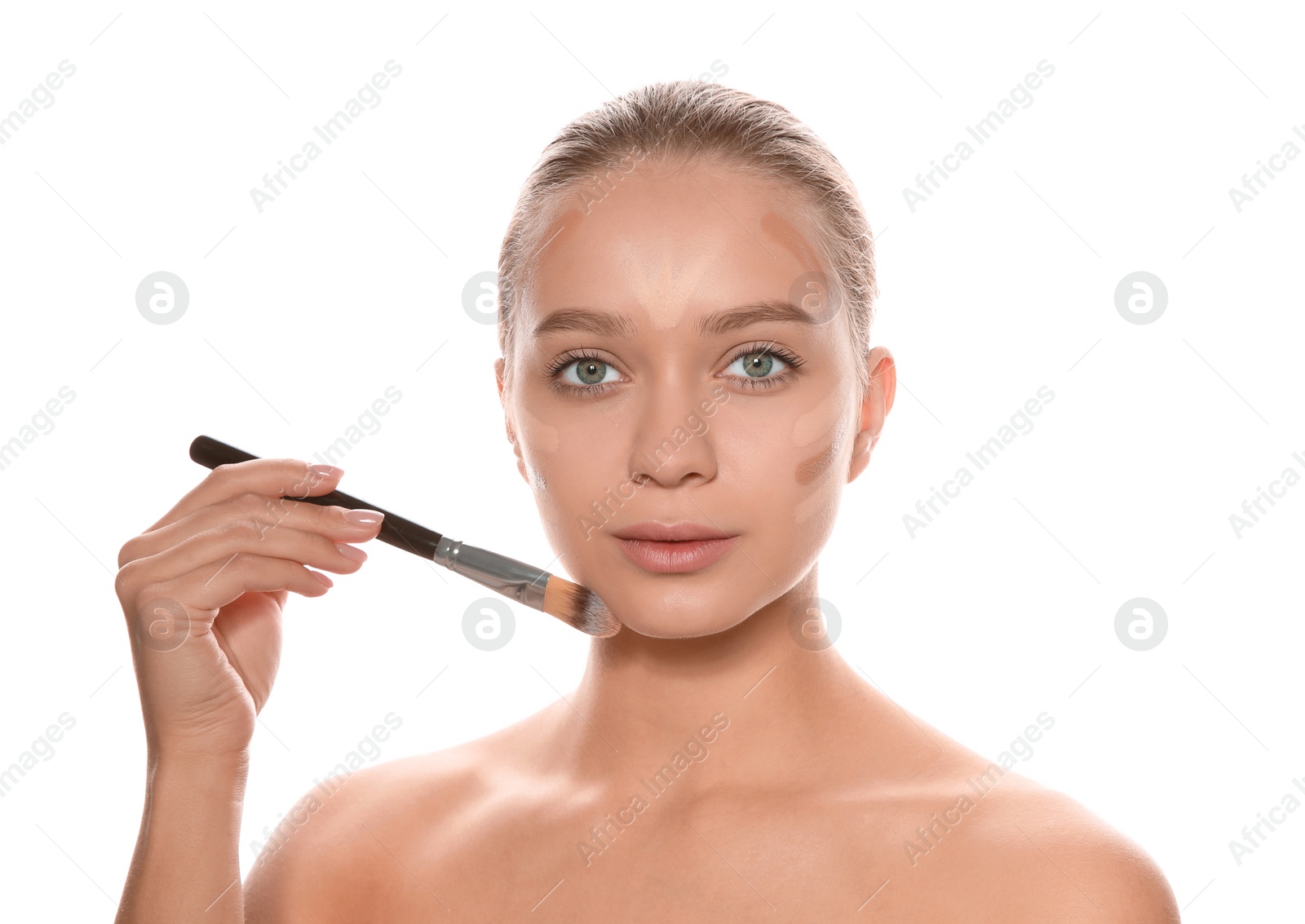 Photo of Young woman applying foundation on her face against white background