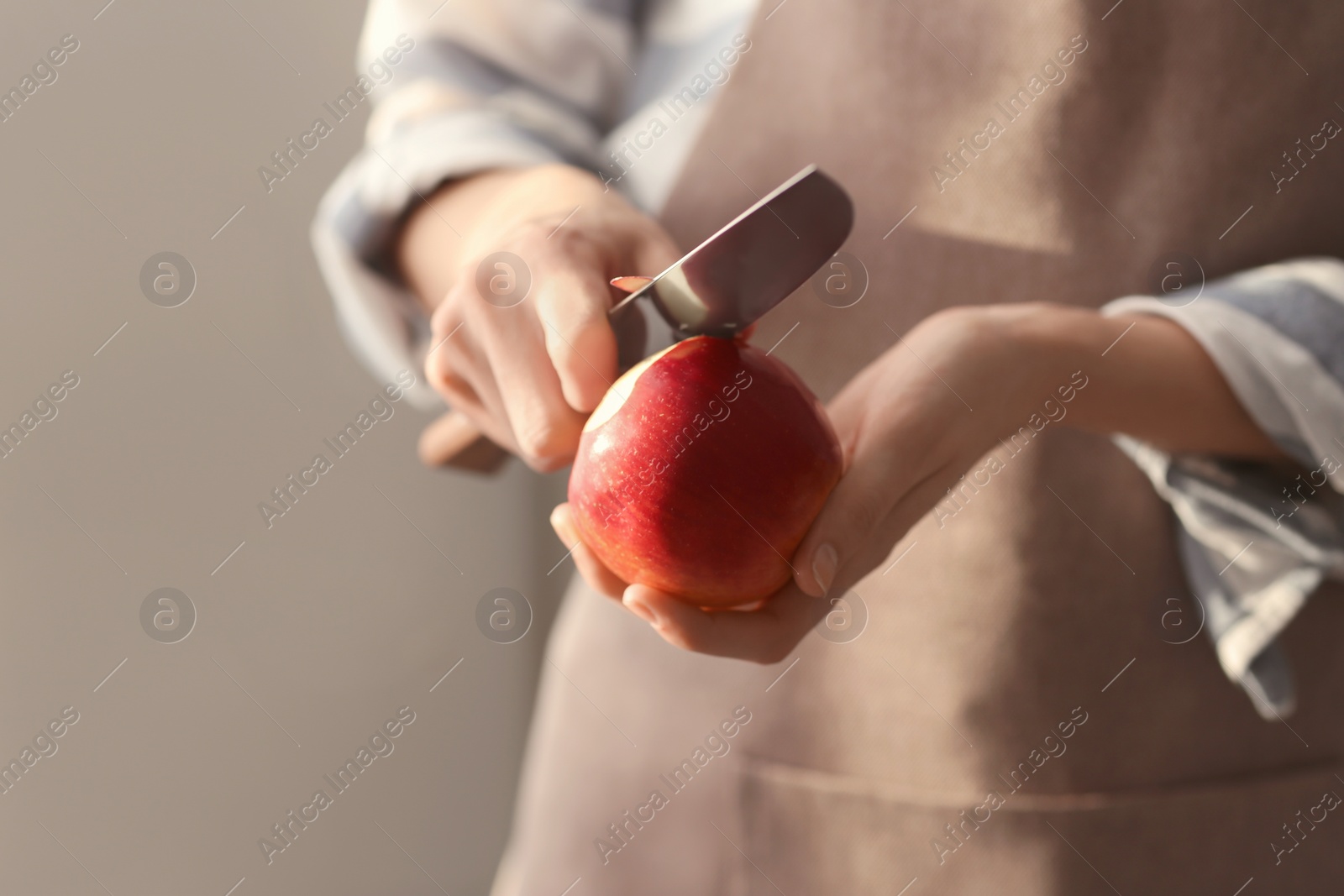 Photo of Woman peeling ripe apple, closeup