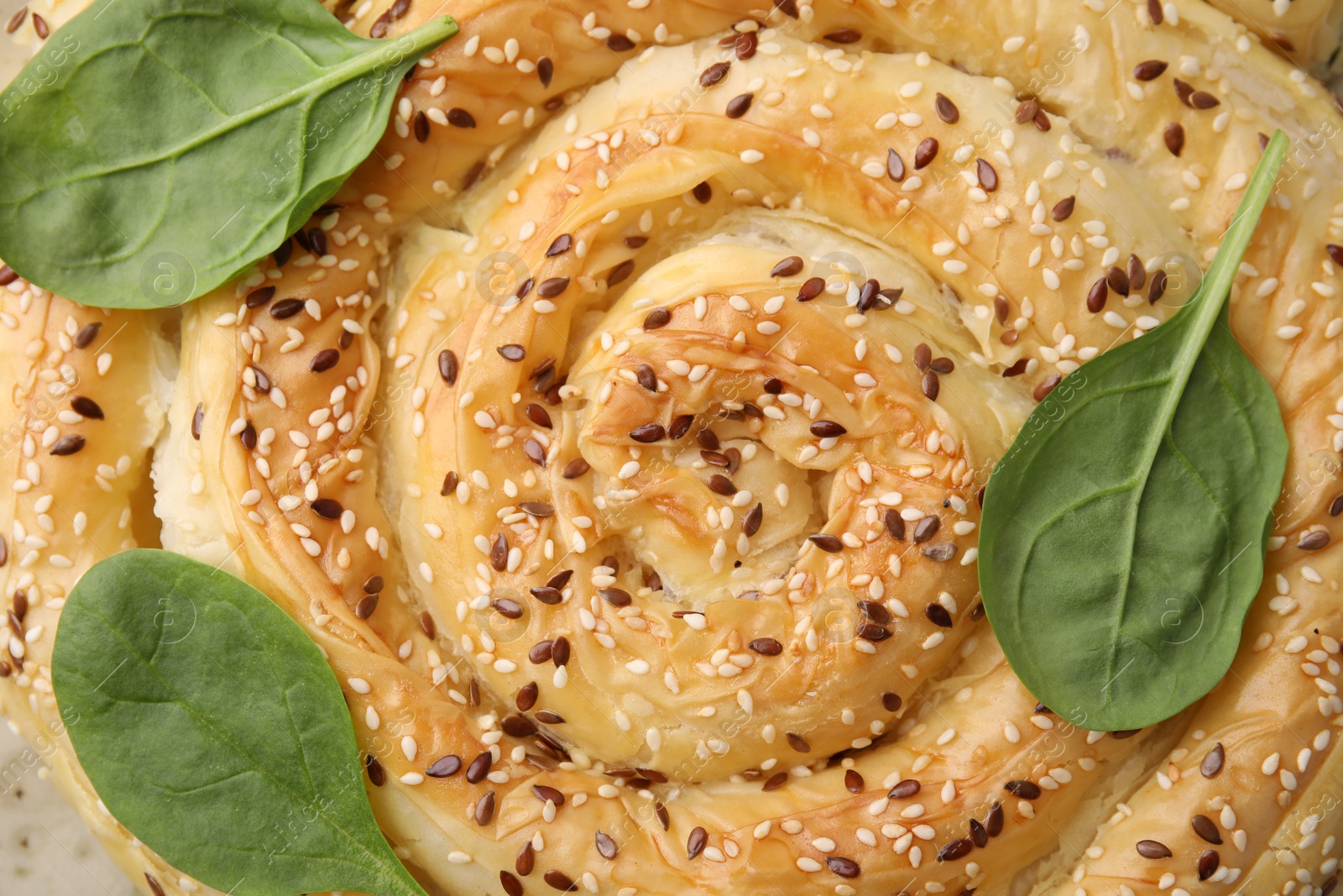 Photo of Delicious puff pastry with spinach as background, closeup