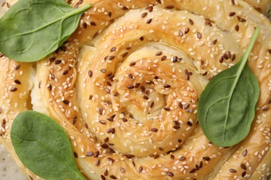 Photo of Delicious puff pastry with spinach as background, closeup