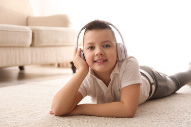 Little boy listening to music on floor at home