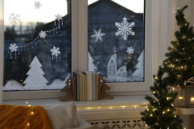 Books near window with beautiful drawing at home. Christmas decor