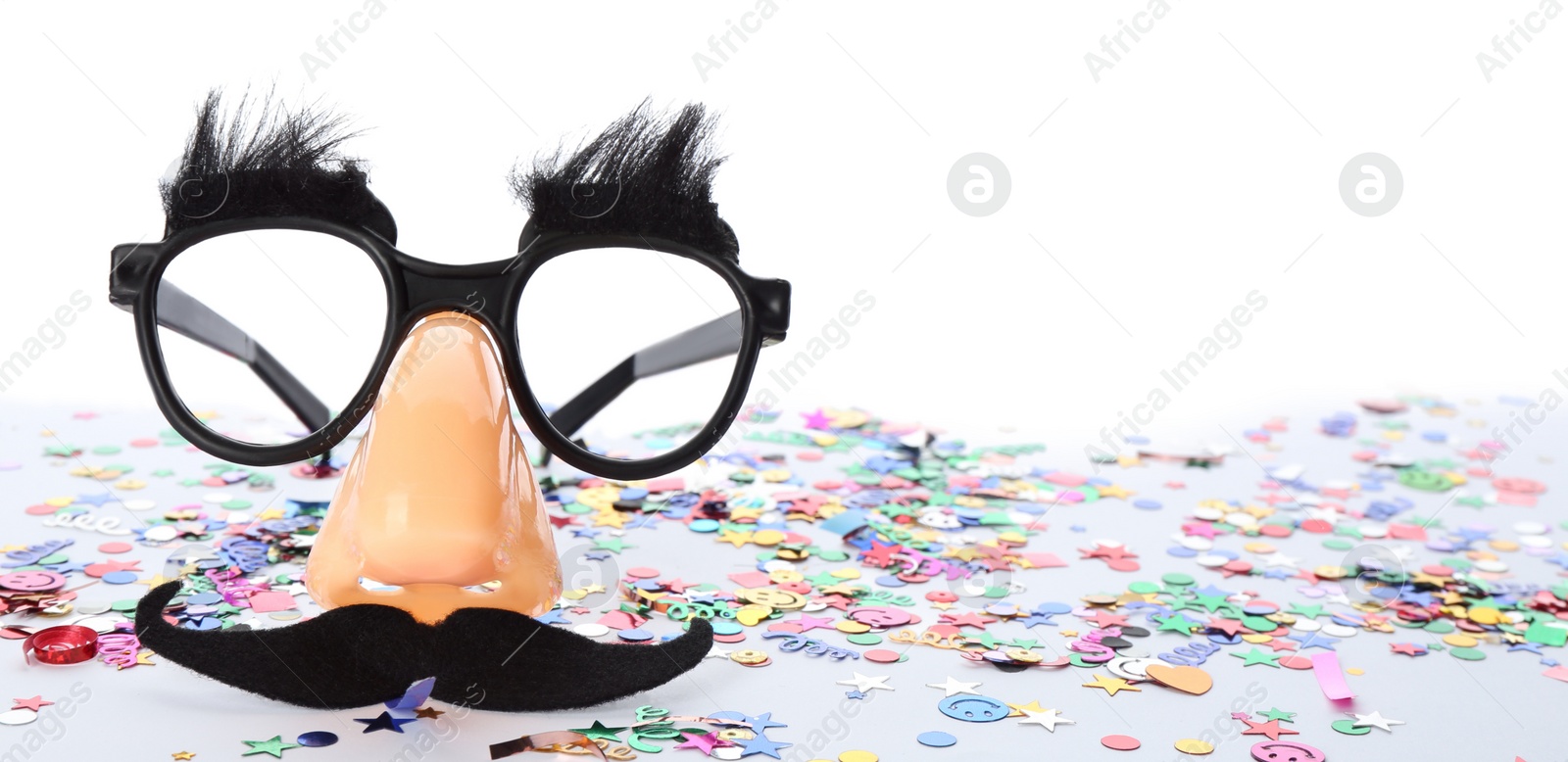 Photo of Funny glasses and confetti isolated on white. Clown's accessory