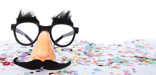 Photo of Funny glasses and confetti isolated on white. Clown's accessory