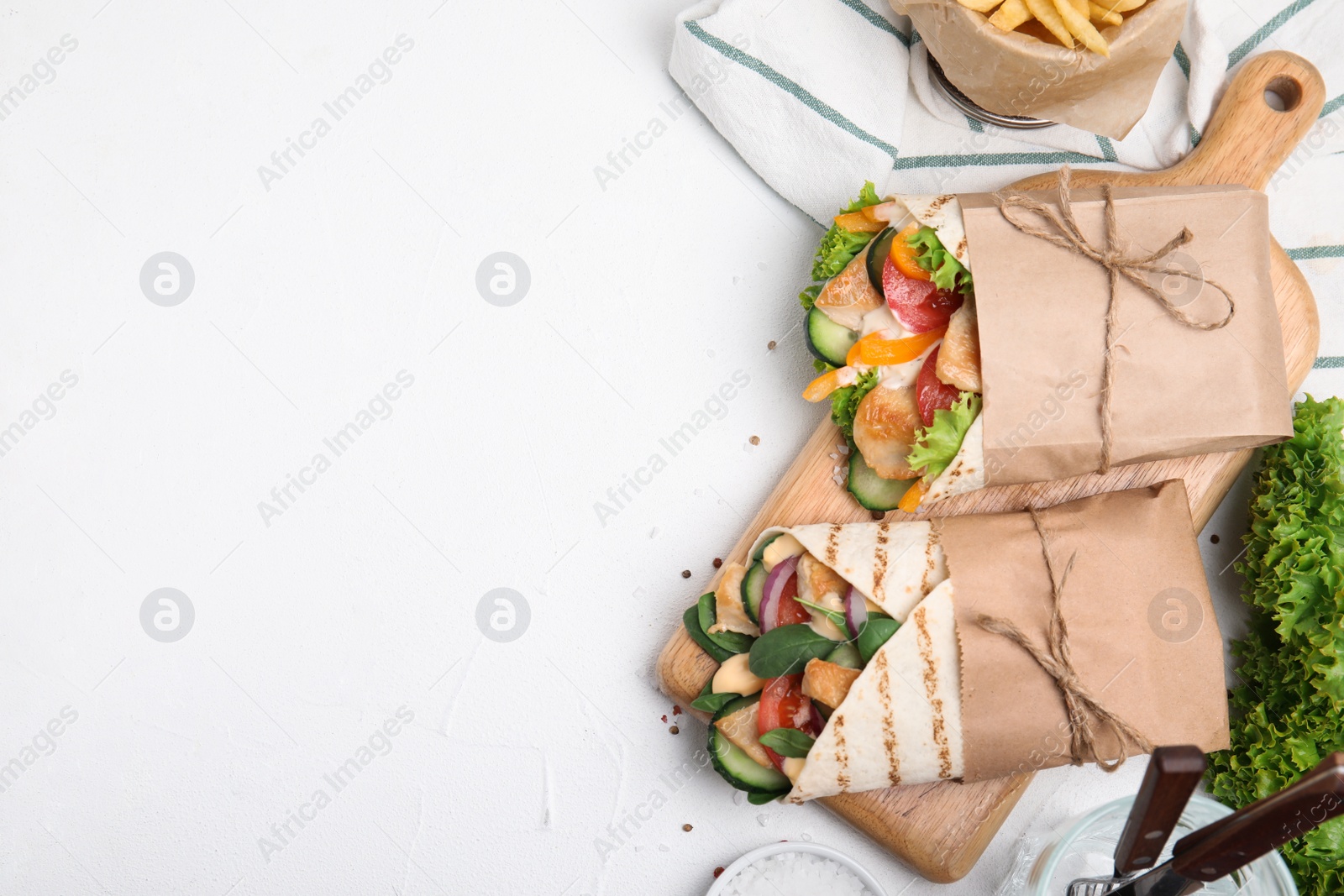 Photo of Delicious shawarmas with chicken and fresh vegetables on white table, flat lay. Space for text