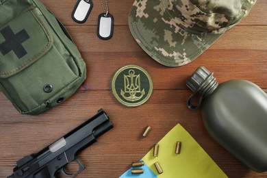 Photo of MYKOLAIV, UKRAINE - SEPTEMBER 26, 2020: Tactical gear and Ukrainian flag on  table, flat lay
