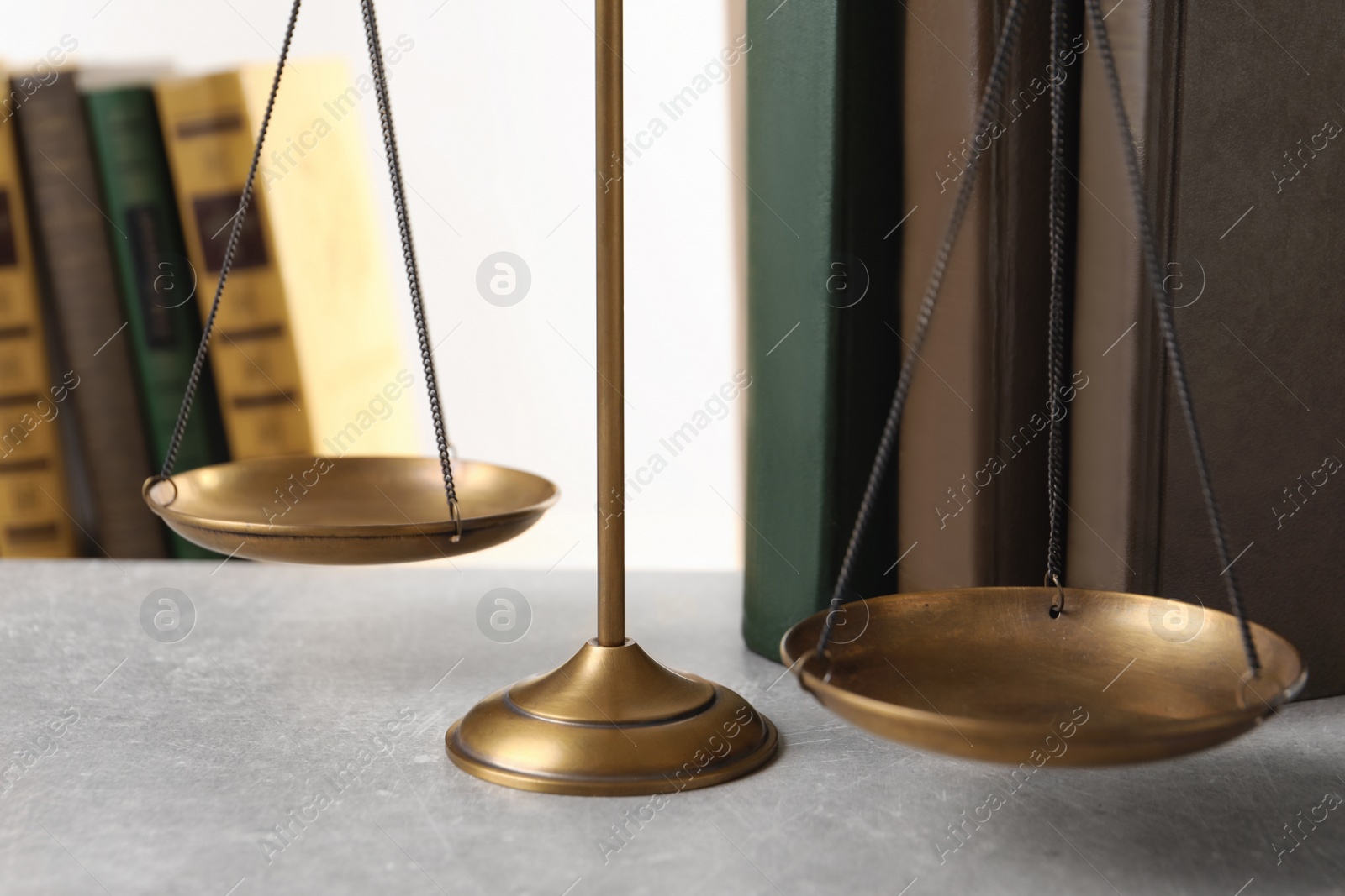 Photo of Scales of justice and books on table, closeup. Law concept