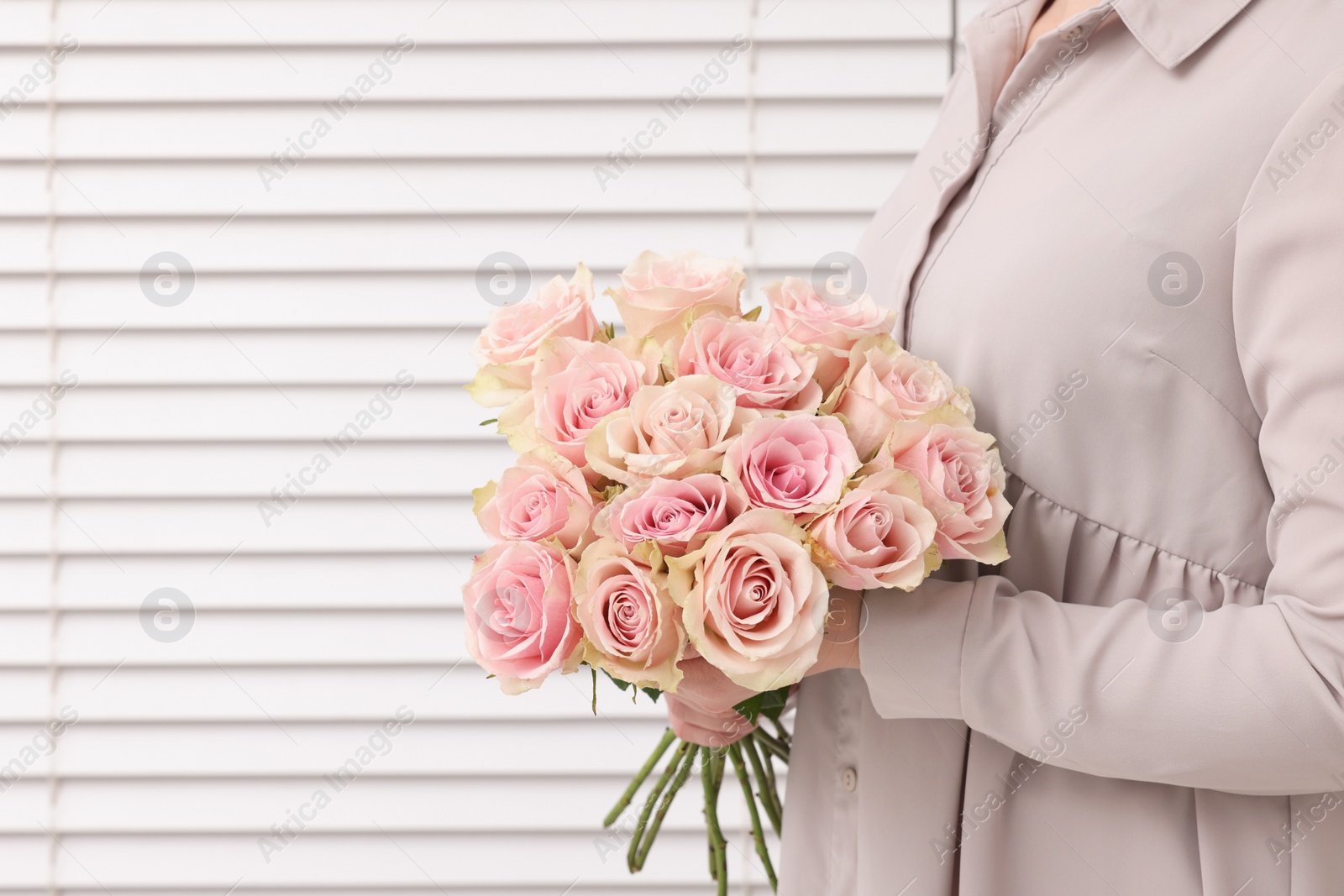 Photo of Woman holding bouquet of beautiful rose flowers indoors, closeup view and space for text. Happy birthday