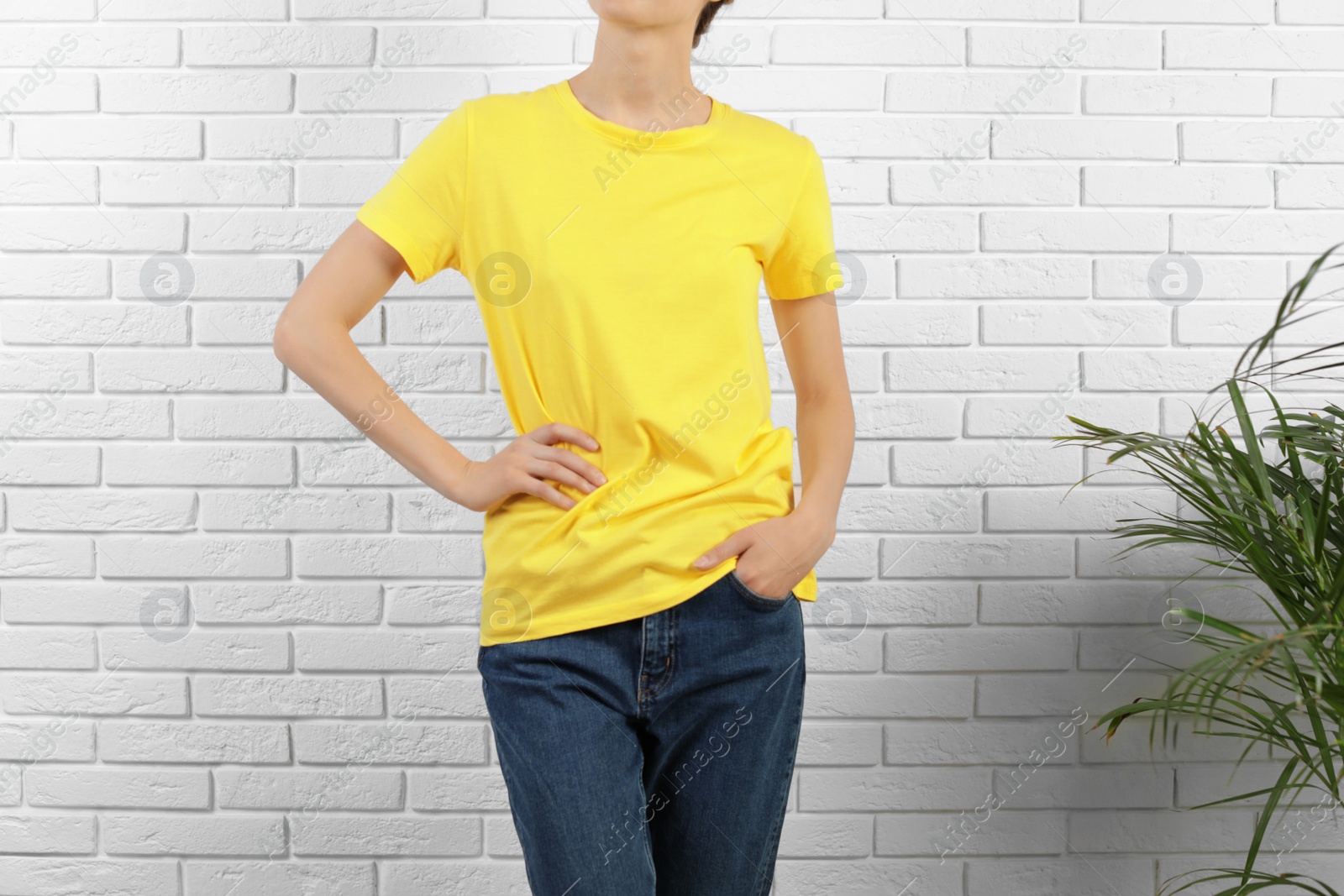 Photo of Woman in bright t-shirt near brick wall. Mock up for design