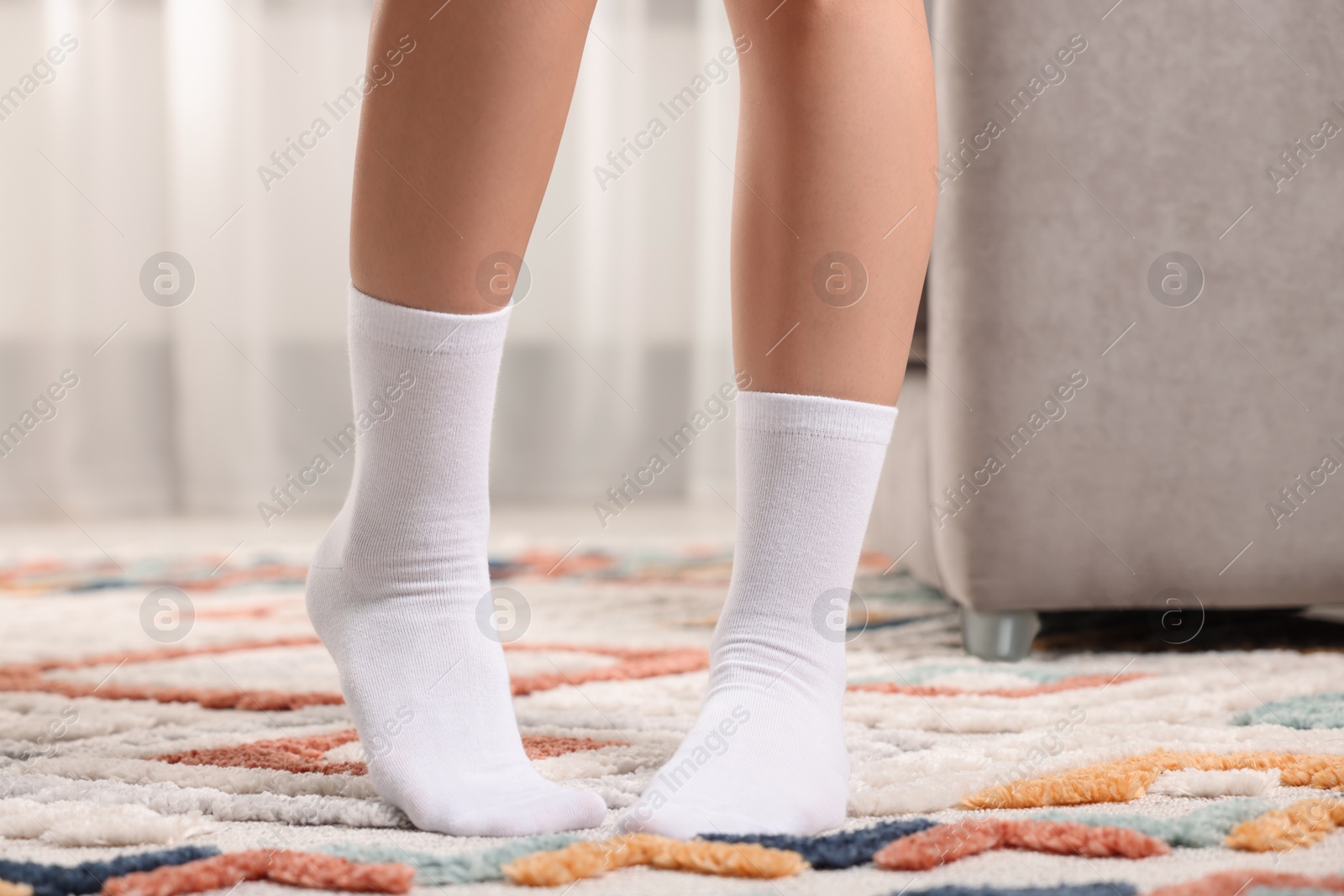 Photo of Woman in stylish white socks indoors, closeup