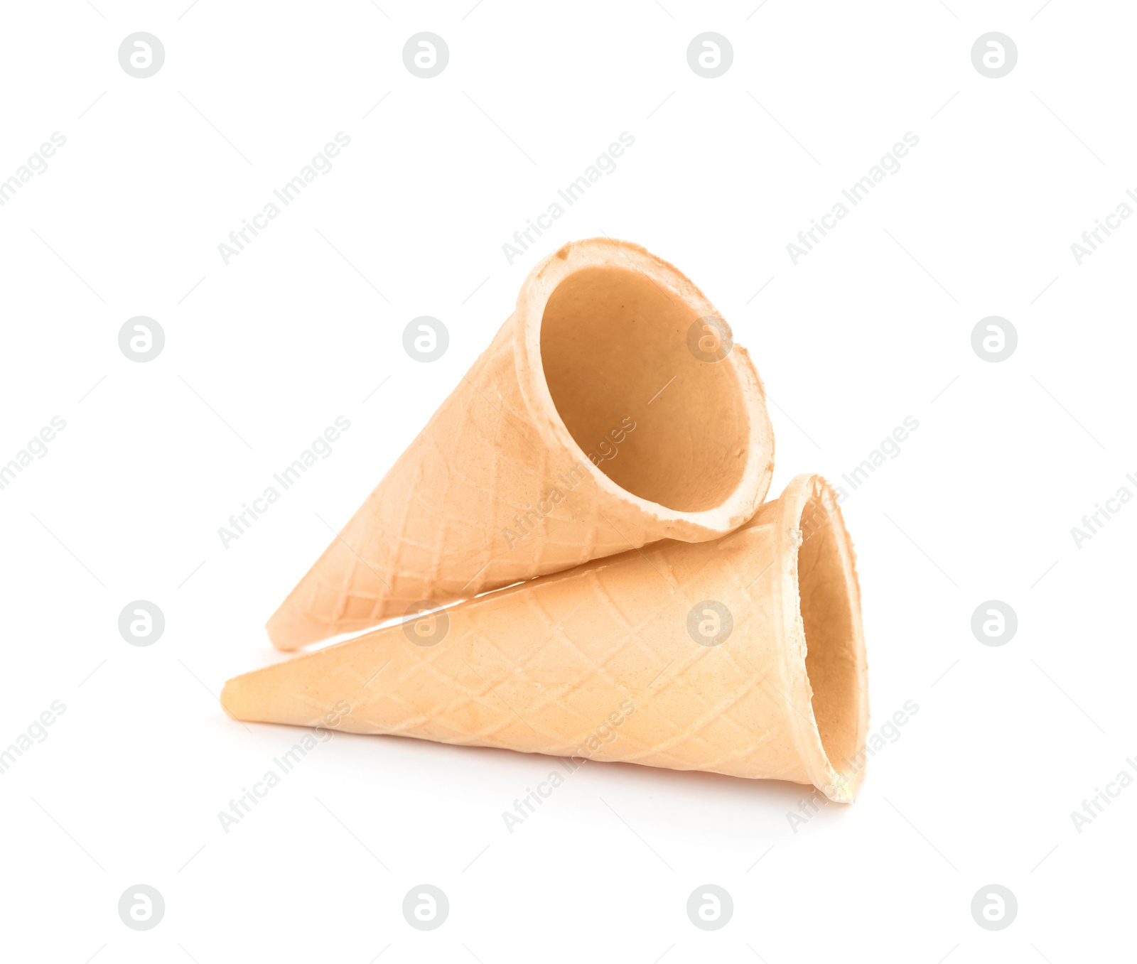 Photo of Empty crispy waffle cones for ice cream on white background