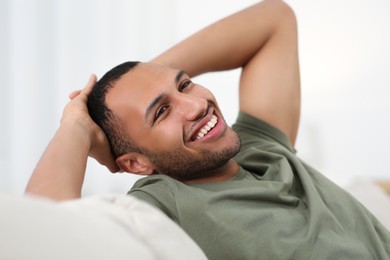 Photo of Portraitsmiling African American man on sofa at home