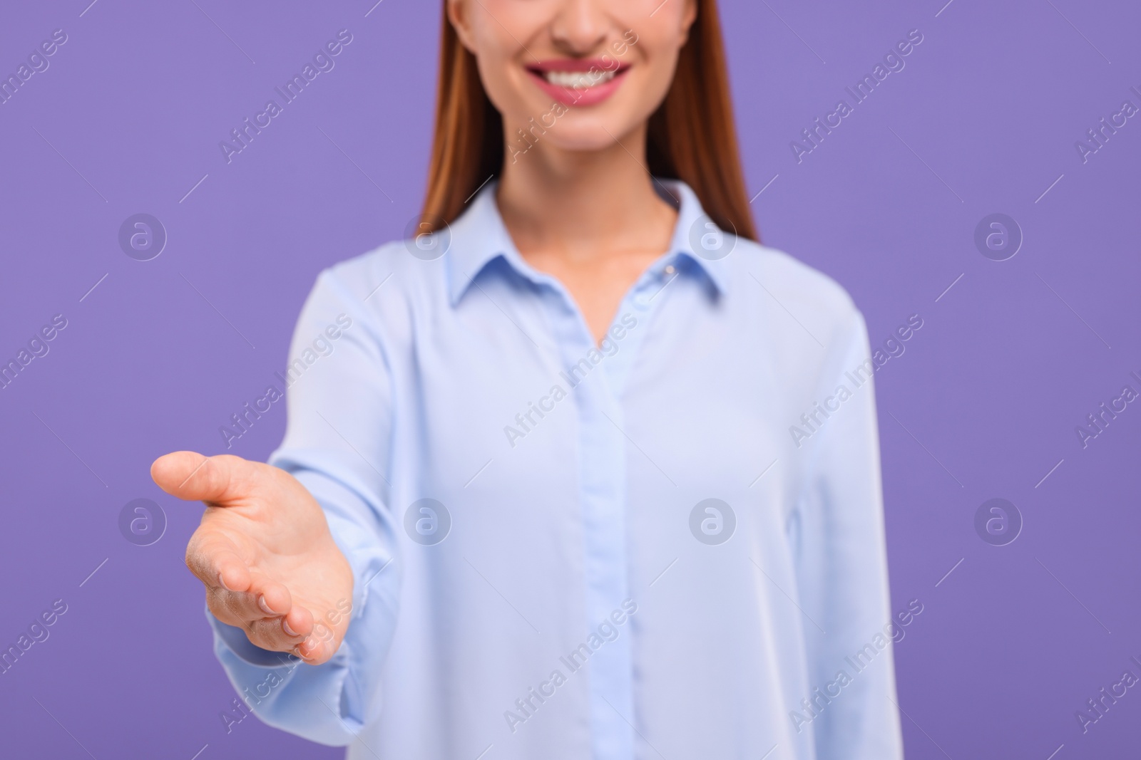 Photo of Woman welcoming and offering handshake on violet background, closeup