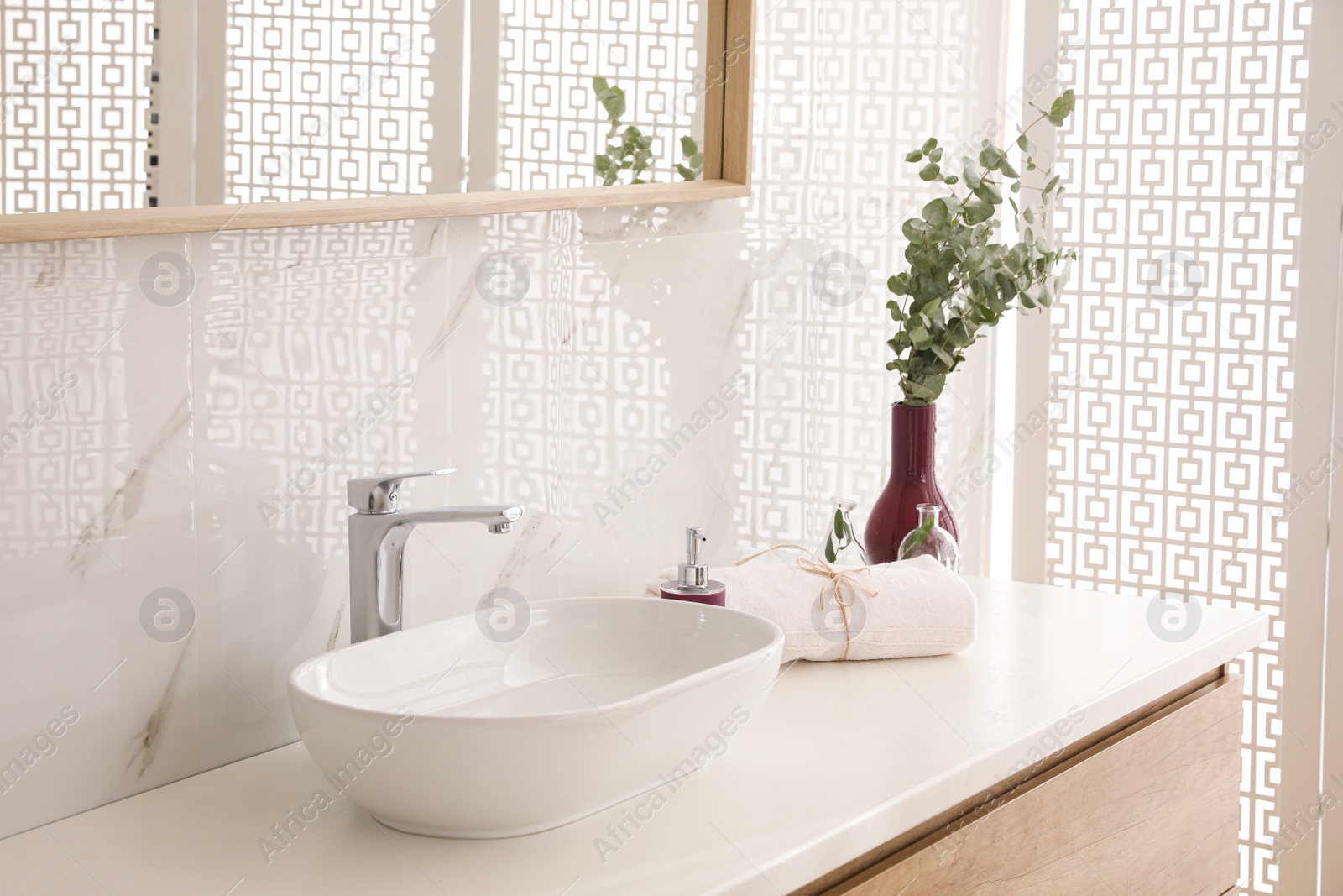 Photo of Countertop with sink, toiletries and plant in bathroom. Interior design