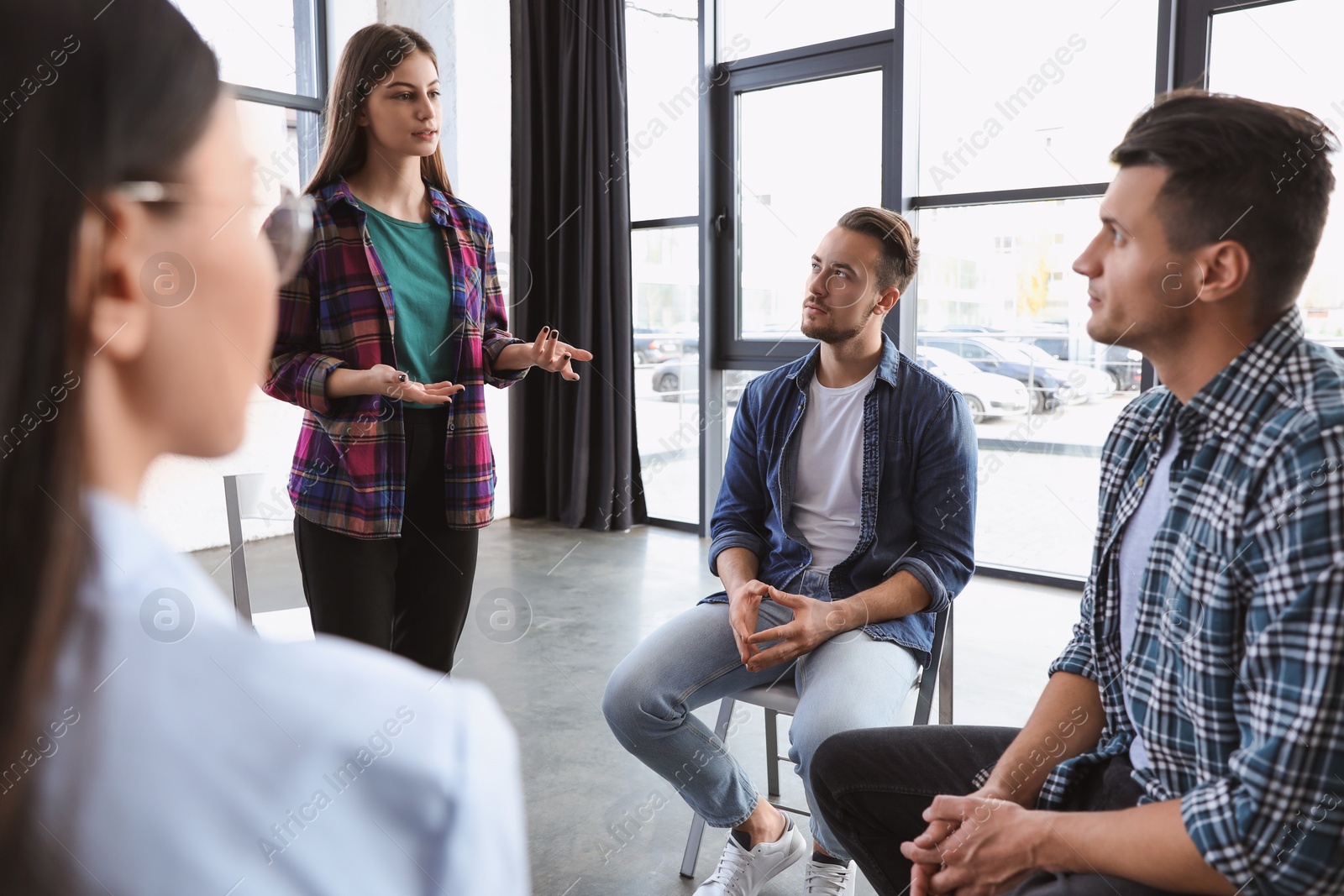 Photo of Psychotherapist working with patients in group therapy session indoors