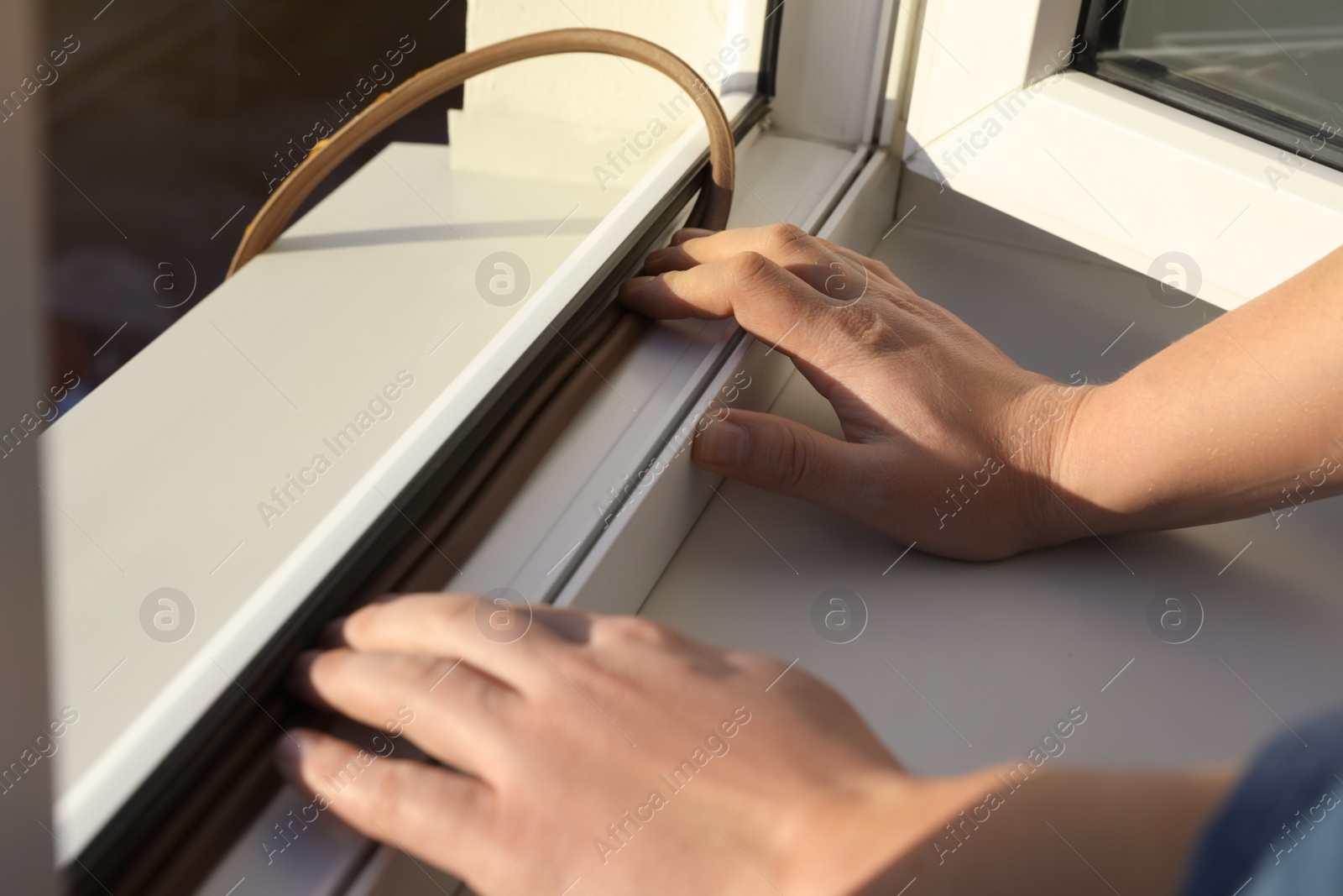 Photo of Construction worker putting sealing foam tape on window, closeup