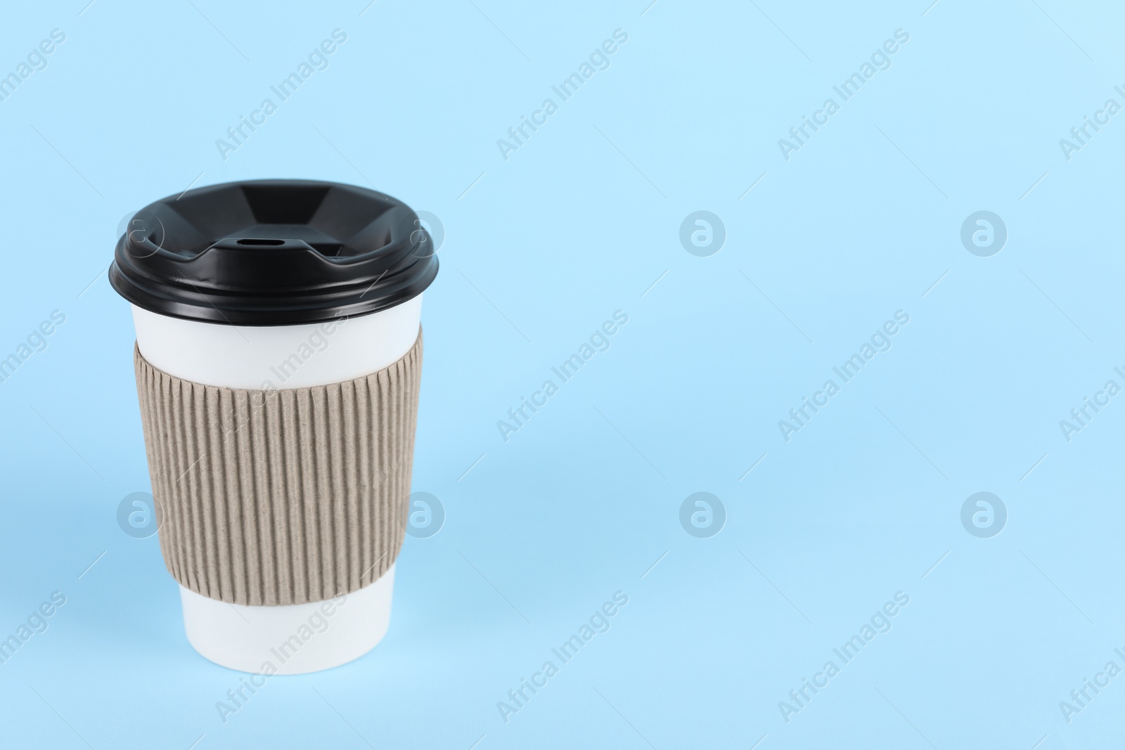 Photo of Paper cup with plastic lid on light blue background, space for text. Coffee to go