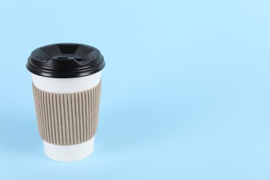 Paper cup with plastic lid on light blue background, space for text. Coffee to go