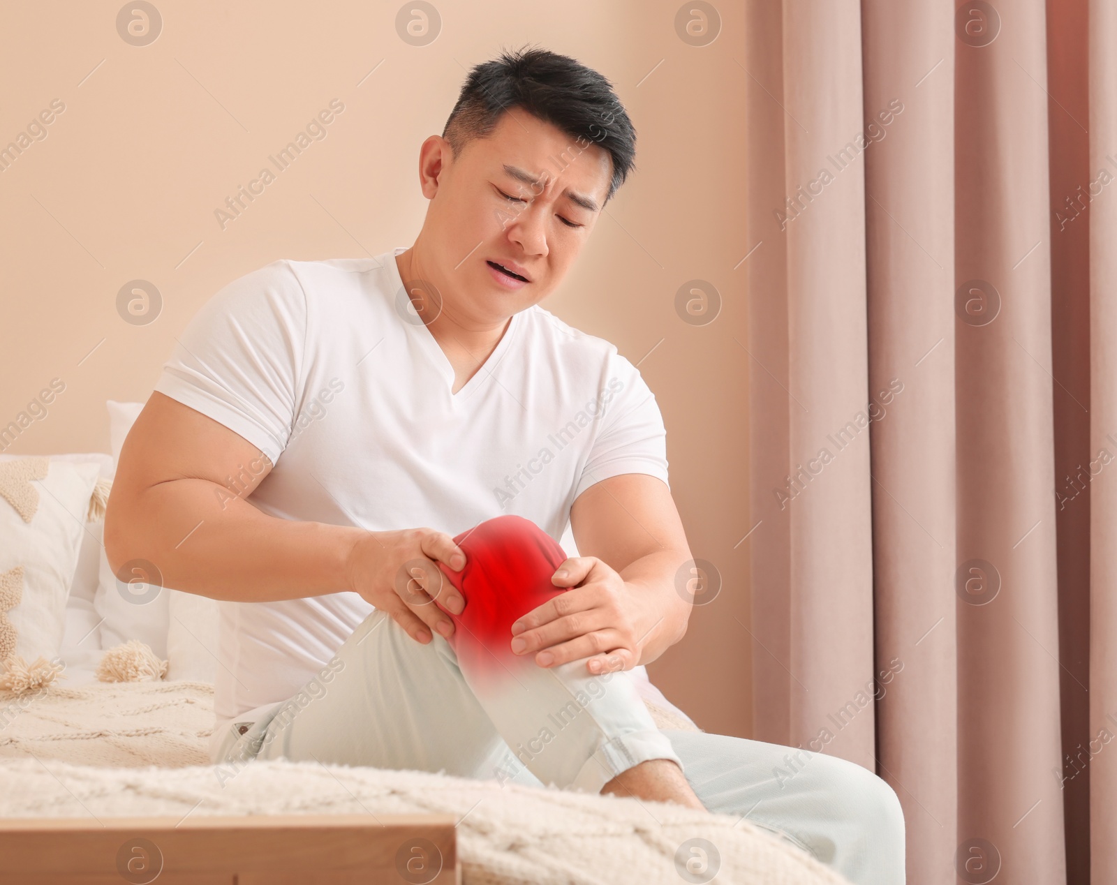 Image of Man suffering from rheumatism in knee at home