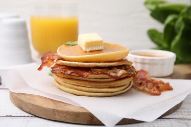 Delicious pancakes with bacon, butter and honey on table, closeup