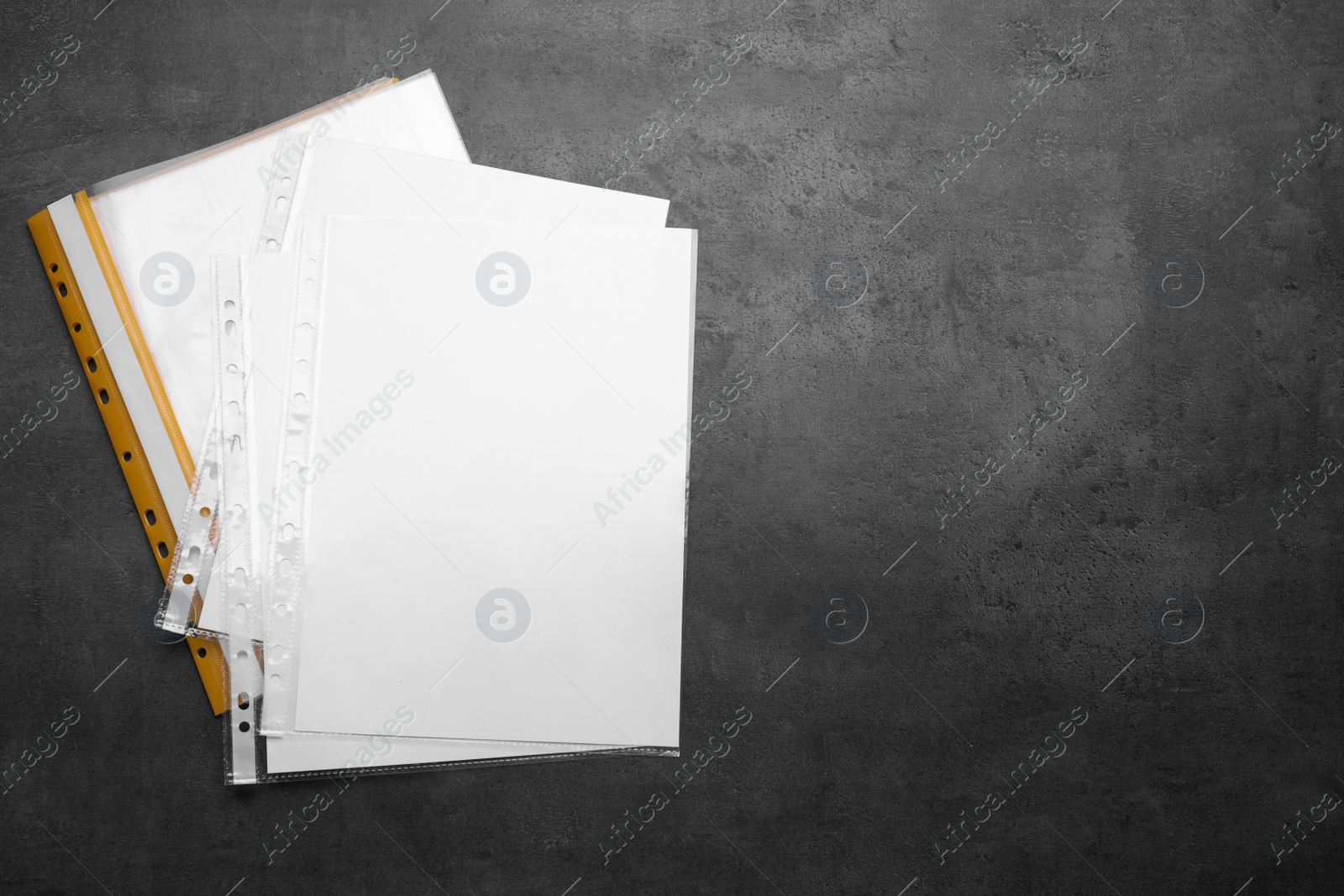 Photo of File folder with punched pockets and paper sheets on grey background, flat lay. Space for text