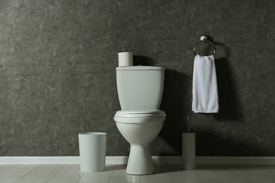 Simple bathroom interior with new toilet bowl near grey wall