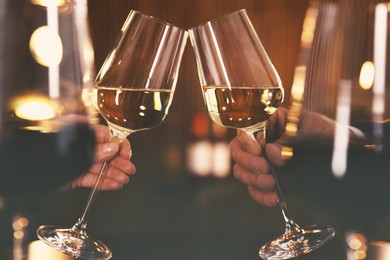 Couple with glasses of wine on blurred background, closeup
