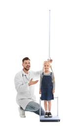 Photo of Doctor measuring little girl's height on white background