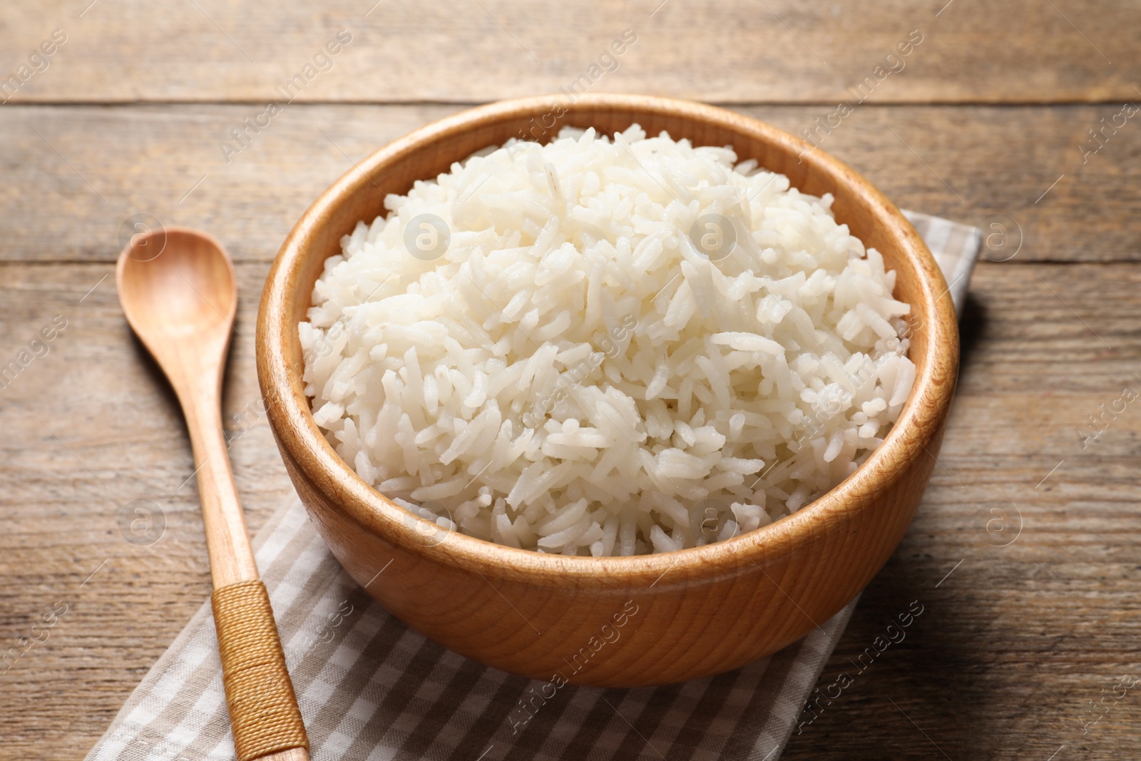 Photo of Bowl of delicious rice on wooden table