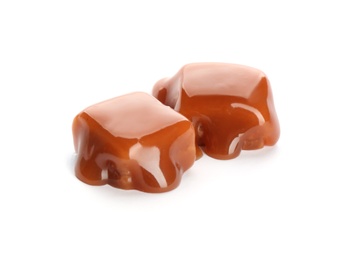 Photo of Delicious candies with caramel sauce on white background