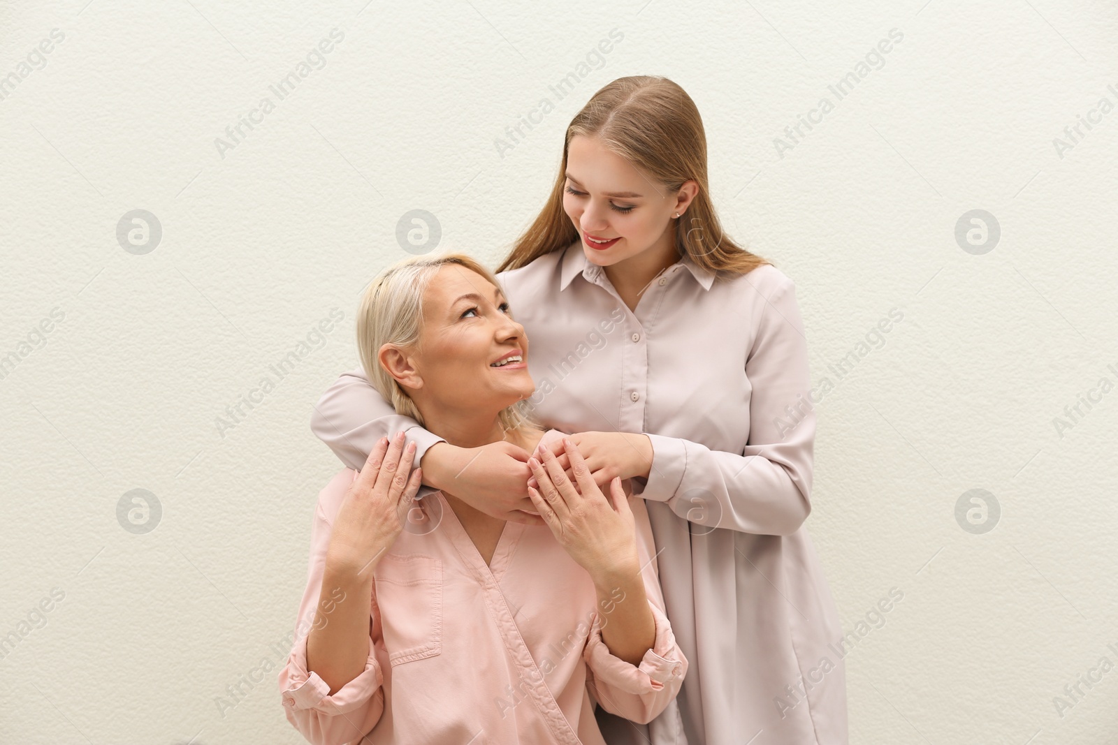 Photo of Mother and her adult daughter on white background