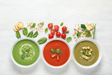 Photo of Flat lay composition with various soups and ingredients on white background. Healthy food