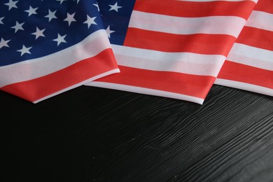 Photo of Flag of USA on black wooden table, top view. Space for text