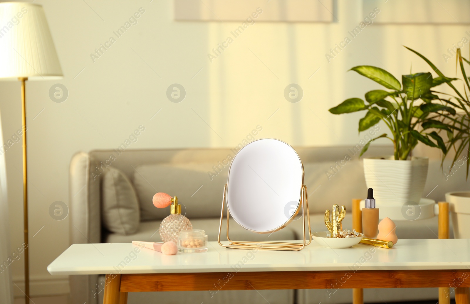 Photo of Mirror and makeup products on white table indoors