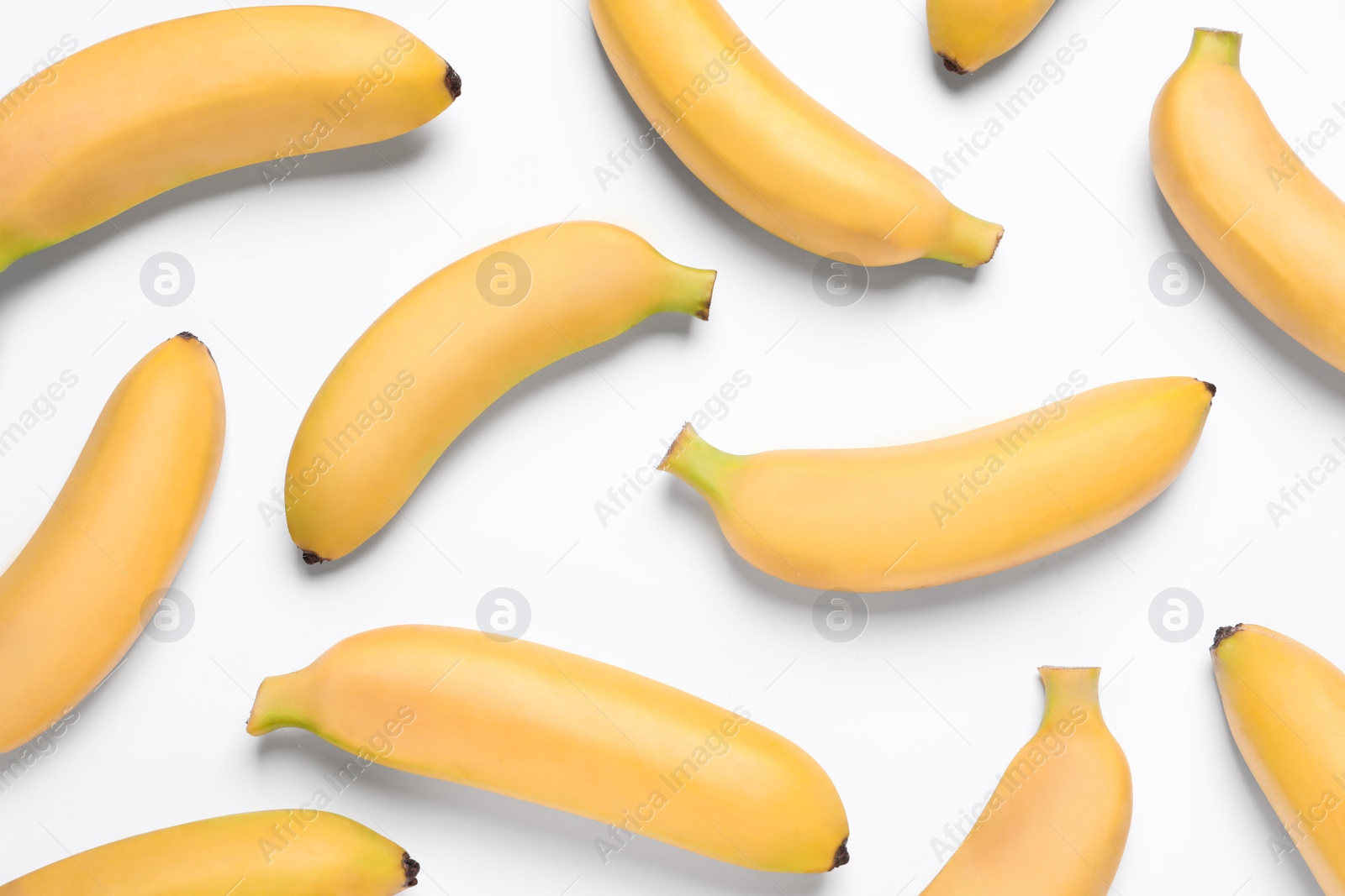 Photo of Sweet ripe baby bananas on white background, top view