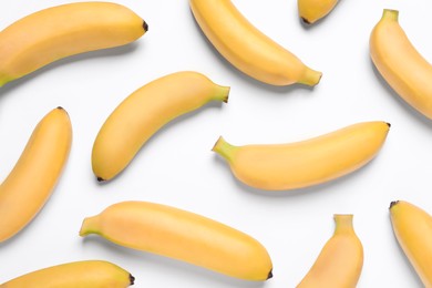 Sweet ripe baby bananas on white background, top view