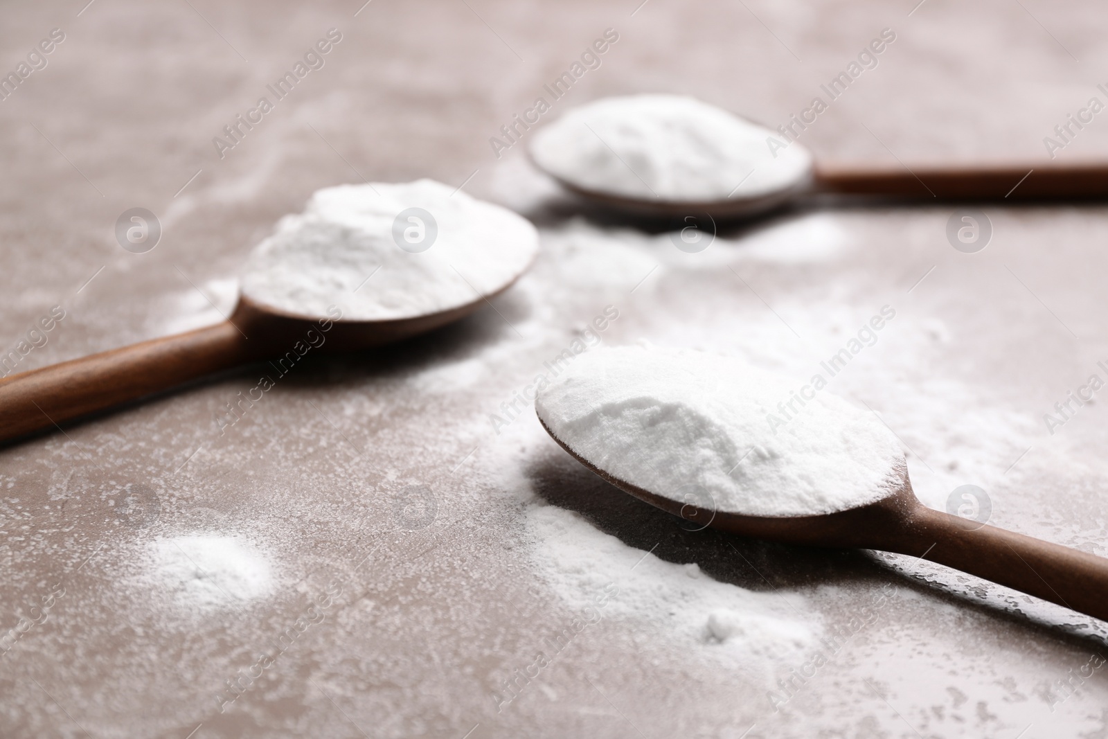 Photo of Spoons with baking soda on grey background