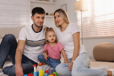 Photo of Family with little daughter spending time together at home