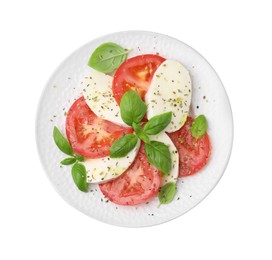 Photo of Plate of delicious Caprese salad with herbs isolated on white, top view