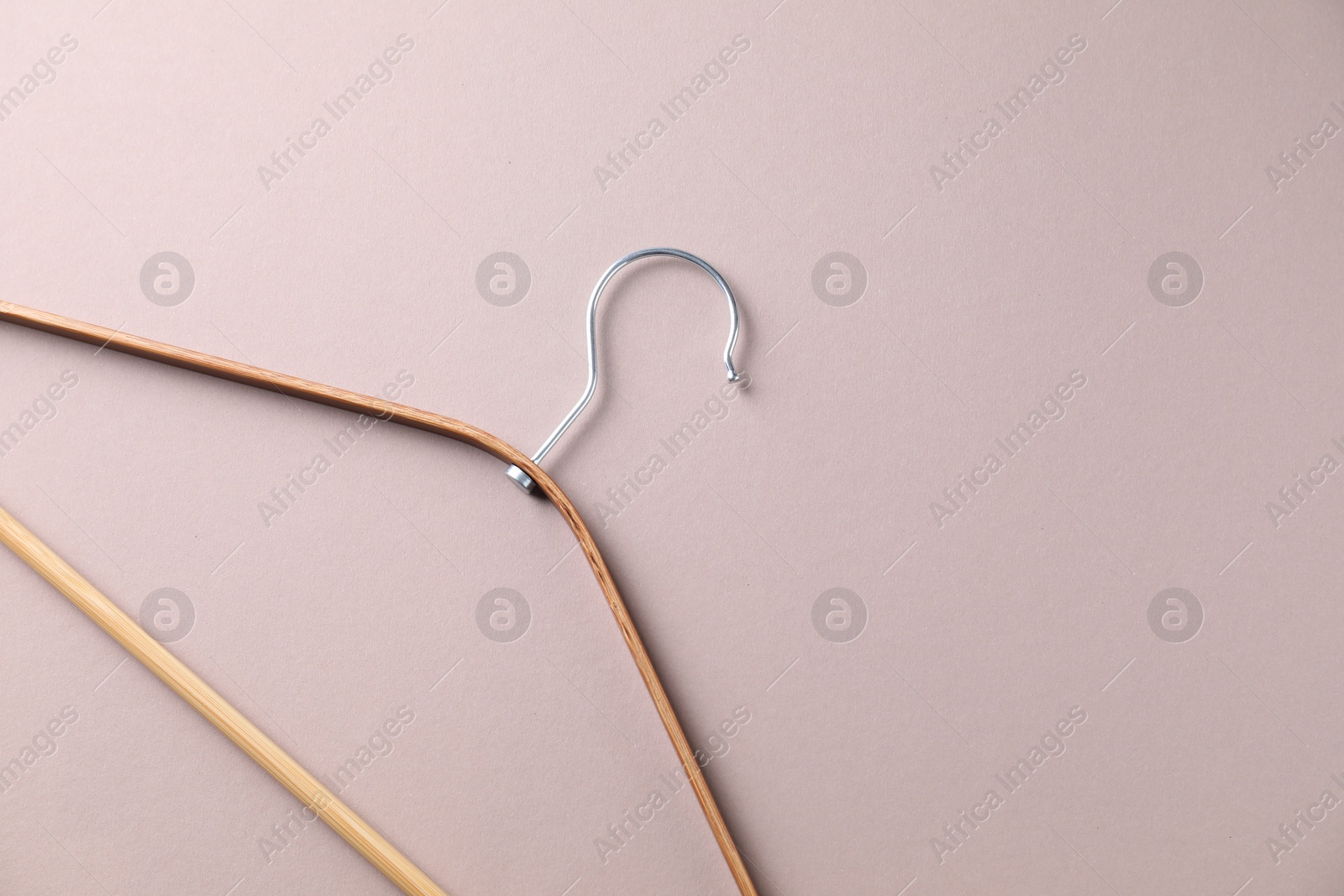 Photo of One wooden hanger on beige background, top view. Space for text