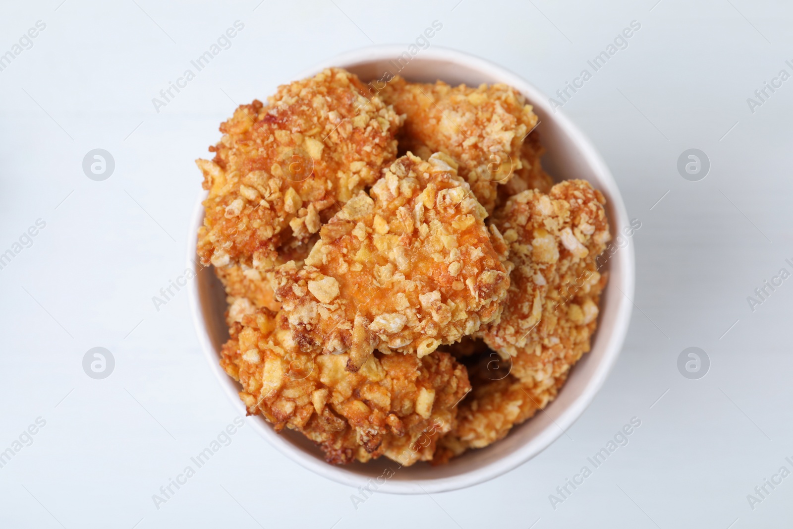 Photo of Bucket with yummy nuggets on white wooden table, top view