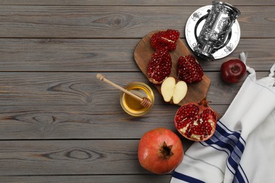 Photo of Flat lay composition with Rosh Hashanah holiday attributes on grey wooden table. Space for text