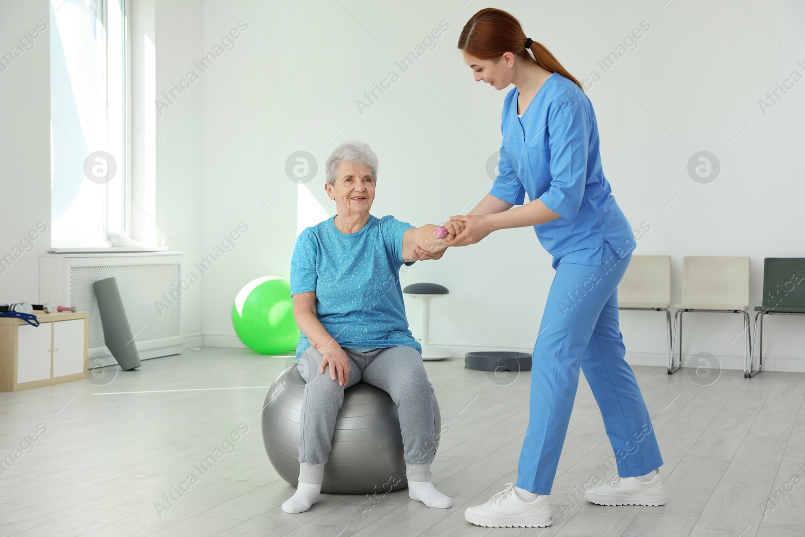 Photo of Professional physiotherapist working with elderly patient in rehabilitation center