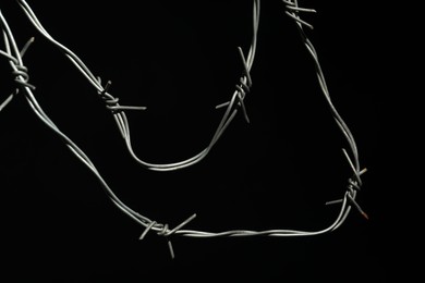 Metal barbed wire on black background, closeup