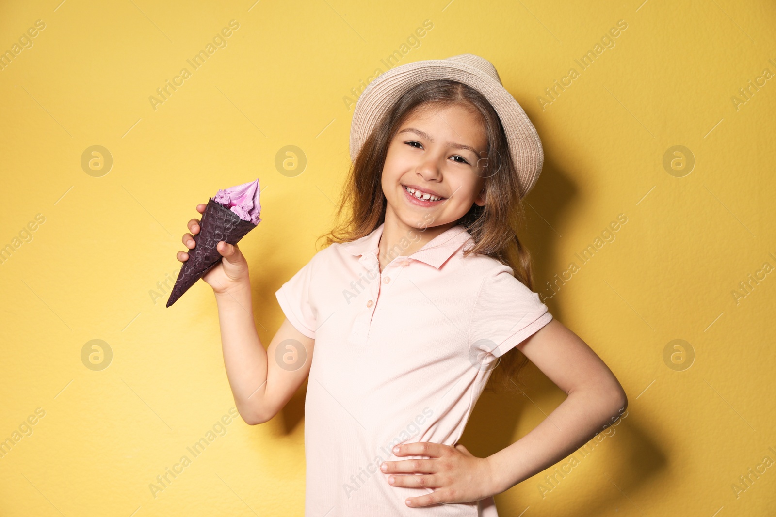 Photo of Adorable little girl with delicious ice cream against color background