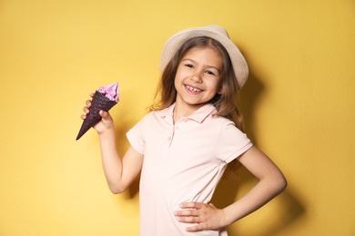 Photo of Adorable little girl with delicious ice cream against color background