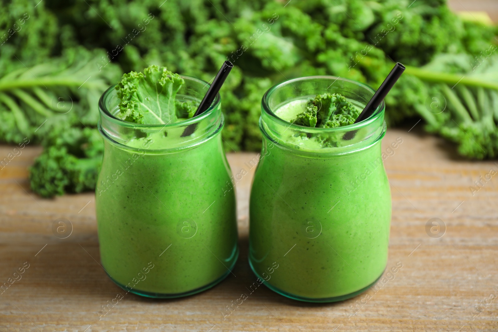 Photo of Tasty fresh kale smoothie on wooden table, closeup